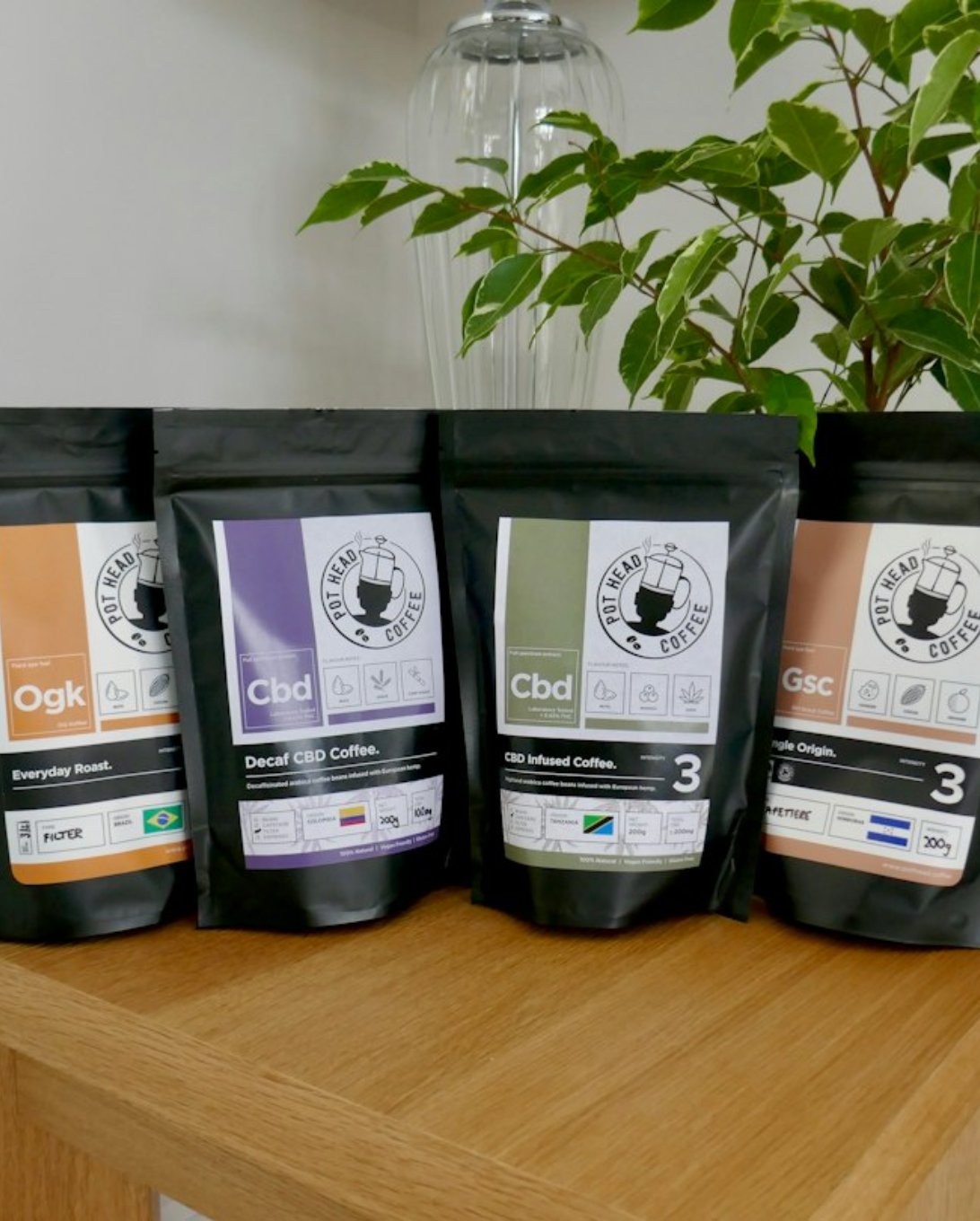 A row of coffee bags with colour-coded labels on a wooden table.